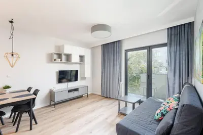 a living room with a blue couch and a table at Park Krowoderski Comfort Apartment by BookingHost in Kraków