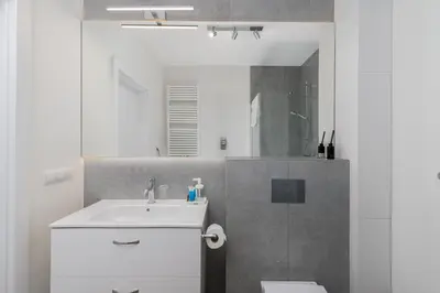 a bathroom with a sink and a toilet and a mirror at Park Krowoderski Comfort Apartment by BookingHost in Kraków