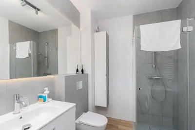 a bathroom with a shower and a toilet and a sink at Park Krowoderski Comfort Apartment by BookingHost in Kraków