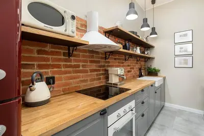 a kitchen with a microwave and a brick wall at Nobel Apartment - BEST LOCATION! in Kraków
