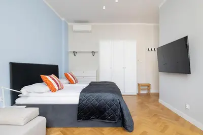 a bedroom with a large bed and a couch at Modern Studio Kazimierz for 4 Guests only 1 km to Wawel Castle by Noclegi Renters in Kraków