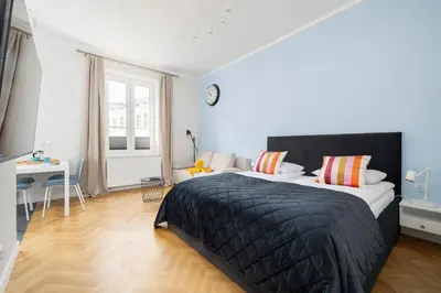 a bedroom with a large bed and a desk at Modern Studio Kazimierz for 4 Guests only 1 km to Wawel Castle by Noclegi Renters in Kraków