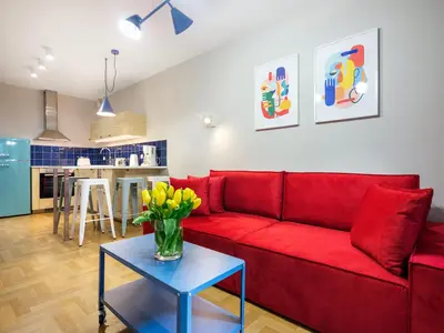 a living room with a red couch and a table at Tyzenhauz Apartments Vistula with Parking in Kraków