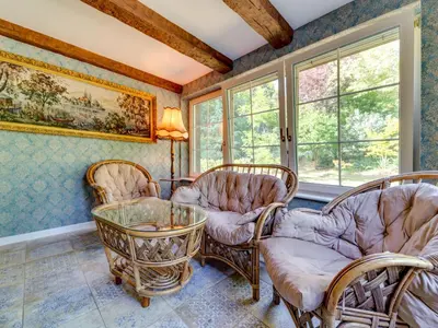 a living room with chairs and a table and windows at Holiday Home Bastrówka by Interhome in Chrosna