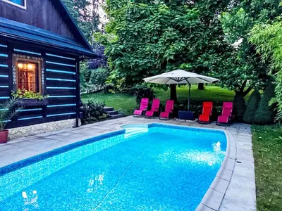 a pool with chairs and an umbrella next to a house at Holiday Home Bastrówka by Interhome in Chrosna