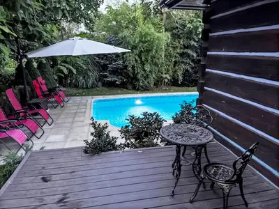 a wooden deck with a table and chairs next to a swimming pool at Holiday Home Bastrówka by Interhome in Chrosna