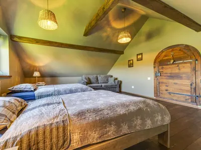 a bedroom with two beds and a chair at Holiday Home Jura dla Ciebie by Interhome in Cisowa