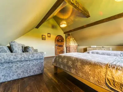a attic bedroom with a bed and a couch at Holiday Home Jura dla Ciebie by Interhome in Cisowa