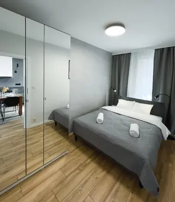 a bedroom with a bed and a glass wall at Like Home Apartments in Kraków