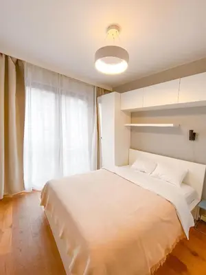 a bedroom with a large white bed and a window at Like Home Apartments in Kraków