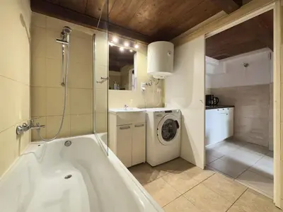 a bathroom with a tub and a washing machine at St Gertruda Apartment Free Parking CityBeat#2 in Kraków