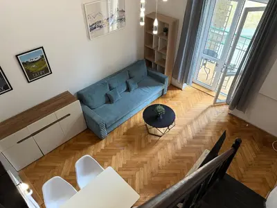 a living room with a blue couch and a table at St Gertruda Apartment Free Parking CityBeat#2 in Kraków