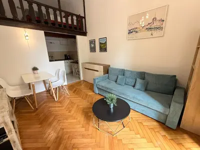 a living room with a blue couch and a table at St Gertruda Apartment Free Parking CityBeat#2 in Kraków