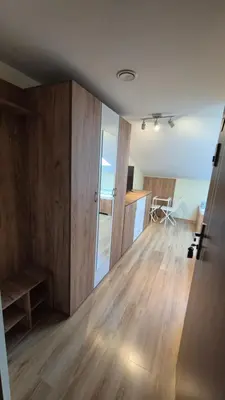 a living room with wooden floors and a sliding door at Noclegi Pod Lasem in Kraków