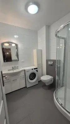 a bathroom with a toilet sink and a washing machine at Noclegi Pod Lasem in Kraków