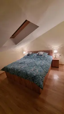 a bedroom with a bed with a blue comforter at Noclegi Pod Lasem in Kraków