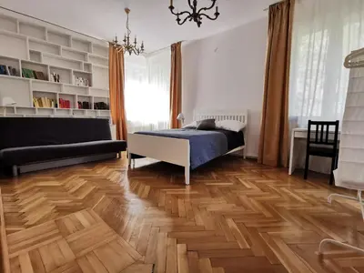 a bedroom with a bed and a wooden floor at Cozy spacious apartment with balcony in Kraków