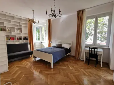 a bedroom with a bed and a desk and a couch at Cozy spacious apartment with balcony in Kraków