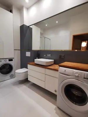 a bathroom with a washing machine and a sink at Cozy spacious apartment with balcony in Kraków