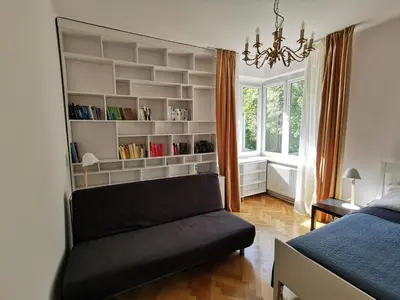 a living room with a couch and a bed at Cozy spacious apartment with balcony in Kraków