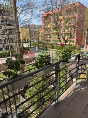 a balcony with a view of a park at Cozy spacious apartment with balcony in Kraków