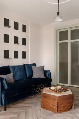 a living room with a blue couch and a coffee table at Sage Apartment in Kraków