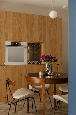 a kitchen with a table and chairs with a vase of flowers at Sage Apartment in Kraków