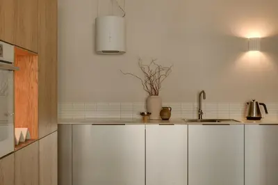 a kitchen with white cabinets and a sink at Sage Apartment in Kraków
