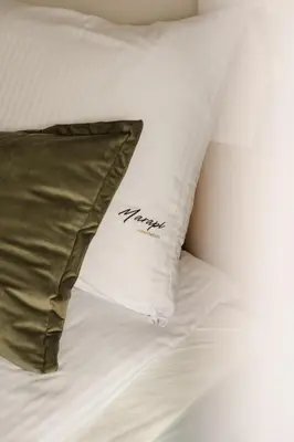 a pillow sitting on top of a bed at Sage Apartment in Kraków