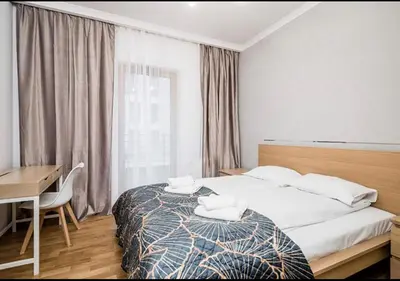 a bedroom with a bed and a desk and a window at GH Luxury Apartment in Kraków