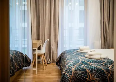 a bedroom with two beds and a desk and a window at GH Luxury Apartment in Kraków