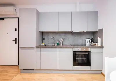 a kitchen with white cabinets and a sink at GH Luxury Apartment in Kraków