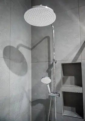 a lamp in a shower with a glass wall at GH Luxury Apartment in Kraków