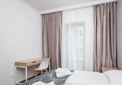 a bedroom with a bed and a desk and a window at GH Luxury Apartment in Kraków
