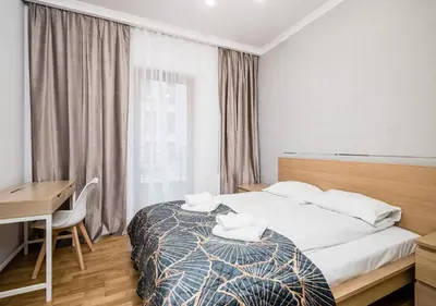 a bedroom with a bed and a desk and a window at GH Luxury Apartment in Kraków