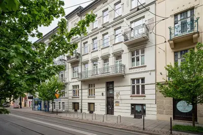 a white building on the side of a street at Classy Cracow Apartments Rakowicka by Noclegi Renters in Kraków