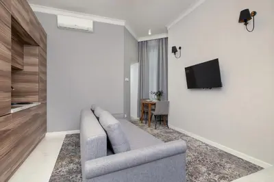a living room with a couch and a tv on a wall at Classy Cracow Apartments Rakowicka by Noclegi Renters in Kraków