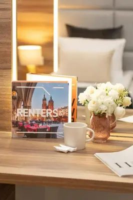 a table with a coffee cup and a picture of a hotel at Classy Cracow Apartments Rakowicka by Noclegi Renters in Kraków