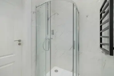 a shower with a glass door in a bathroom at Classy Cracow Apartments Rakowicka by Noclegi Renters in Kraków