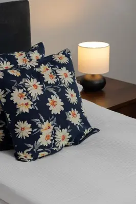 a blue and white pillow on a bed with a lamp at Spacious Apartment for 6 Guests in Krakow with Home Office by Noclegi Renters in Kraków