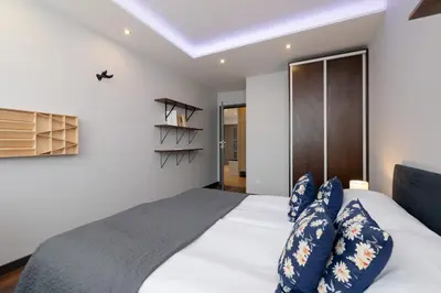 a bedroom with a large bed with blue pillows at Spacious Apartment for 6 Guests in Krakow with Home Office by Noclegi Renters in Kraków