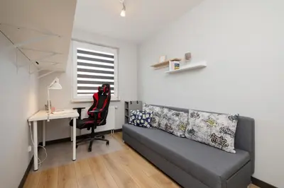 a living room with a couch and a desk and a table at Spacious Apartment for 6 Guests in Krakow with Home Office by Noclegi Renters in Kraków