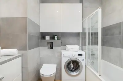 a bathroom with a washing machine and a toilet at Spacious Apartment for 6 Guests in Krakow with Home Office by Noclegi Renters in Kraków