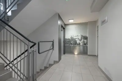 a hallway with stairs and a painting on the wall at Spacious Apartment for 6 Guests in Krakow with Home Office by Noclegi Renters in Kraków