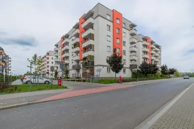 an empty street with a large apartment building at Spacious Apartment for 6 Guests in Krakow with Home Office by Noclegi Renters in Kraków