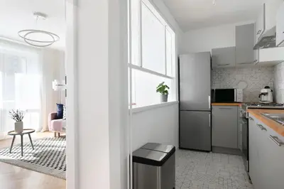 a white kitchen with a refrigerator and a table at Beautiful & Cozy Apartment next to Main Market in Kraków