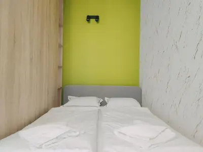 a bed in a room with a green wall at Klimeckiego 8a by Homeprime in Kraków