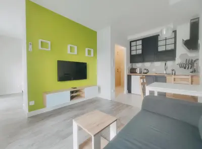a living room with a couch and a tv on a wall at Klimeckiego 8a by Homeprime in Kraków