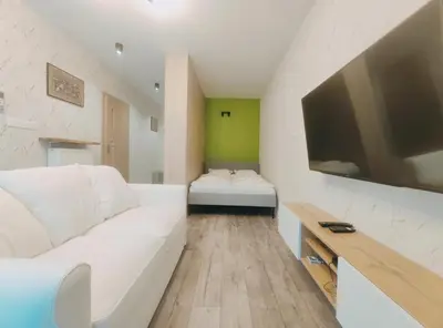 a living room with a white couch and a flat screen tv at Klimeckiego 8a by Homeprime in Kraków