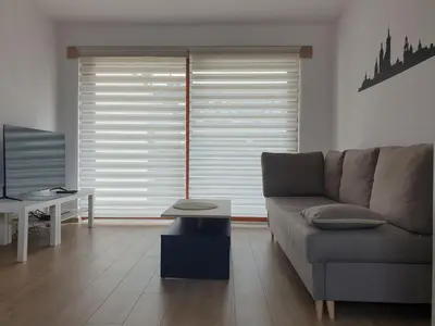 a living room with a couch and a tv at Near the airport- Apartments in Kraków